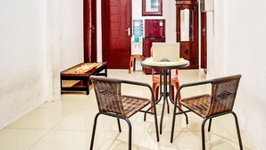 A dining area with two wicker chairs and a small round table. - OYO LIFE 92034 Jay Homestay Syariah (Bandar Lampung)