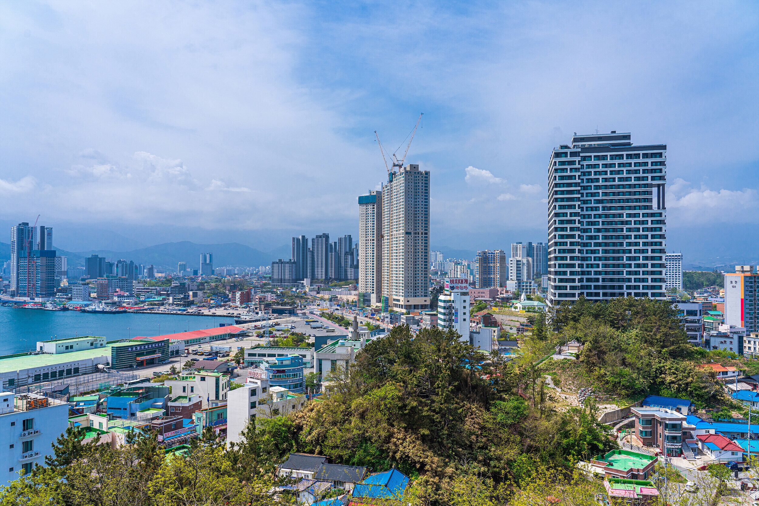 A cityscape with high-rise buildings, a waterfront, and a mix of residential and commercial structures.