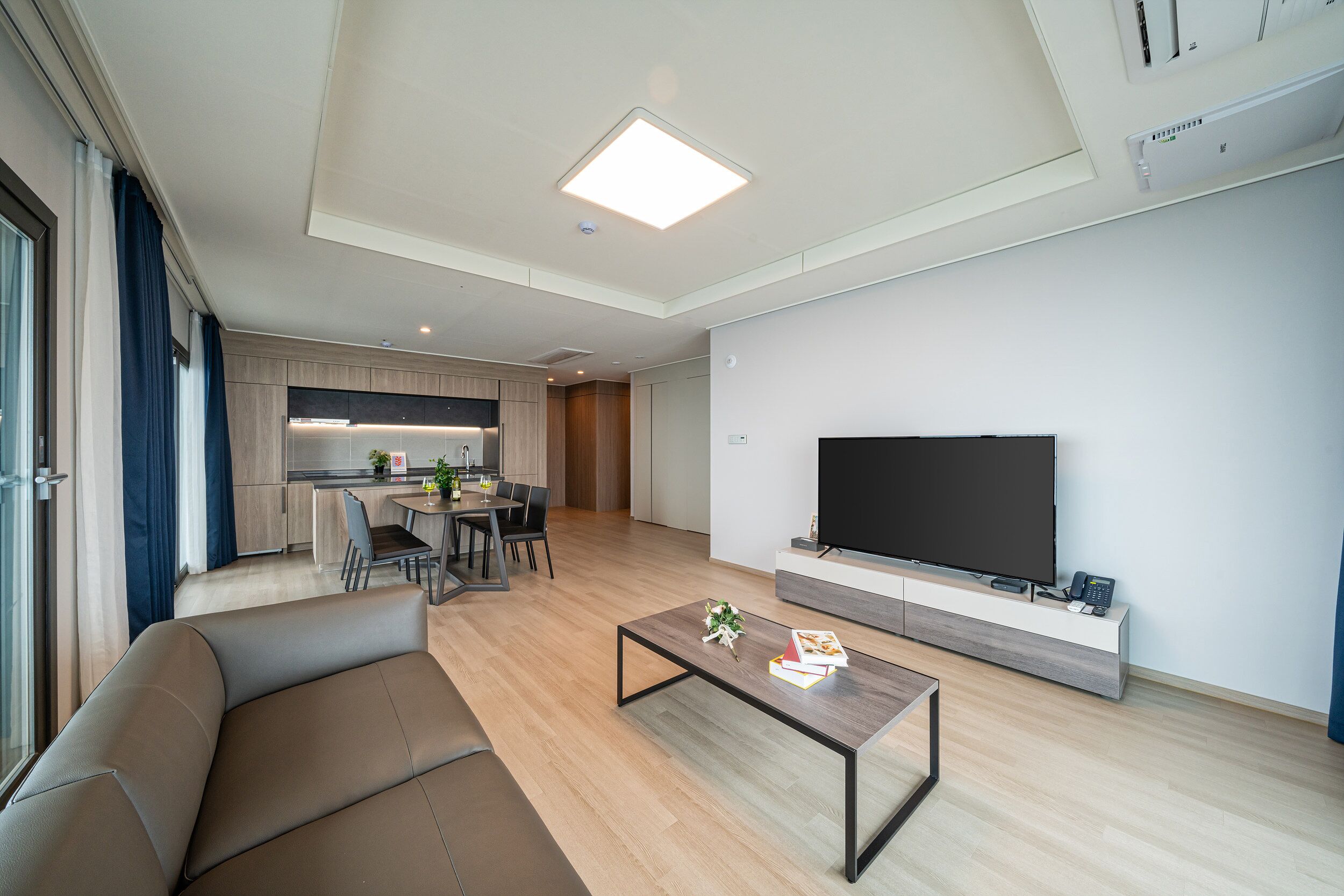 A modern living room with a sofa, a coffee table, and a flat-screen TV.
