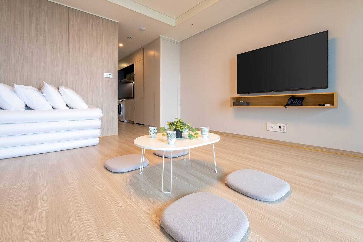 Una sala de estar moderna con un sofá, una mesa de centro y un televisor montado en la pared.