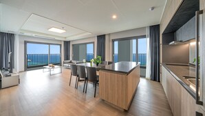 Un apartamento moderno con cocina, comedor y balcón con vista al mar.
