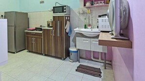 A kitchen with a microwave, sink, and fan. - Darul Salam Orkid Inn (Kerteh)