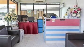 A reception area with a desk, computer, and seating.