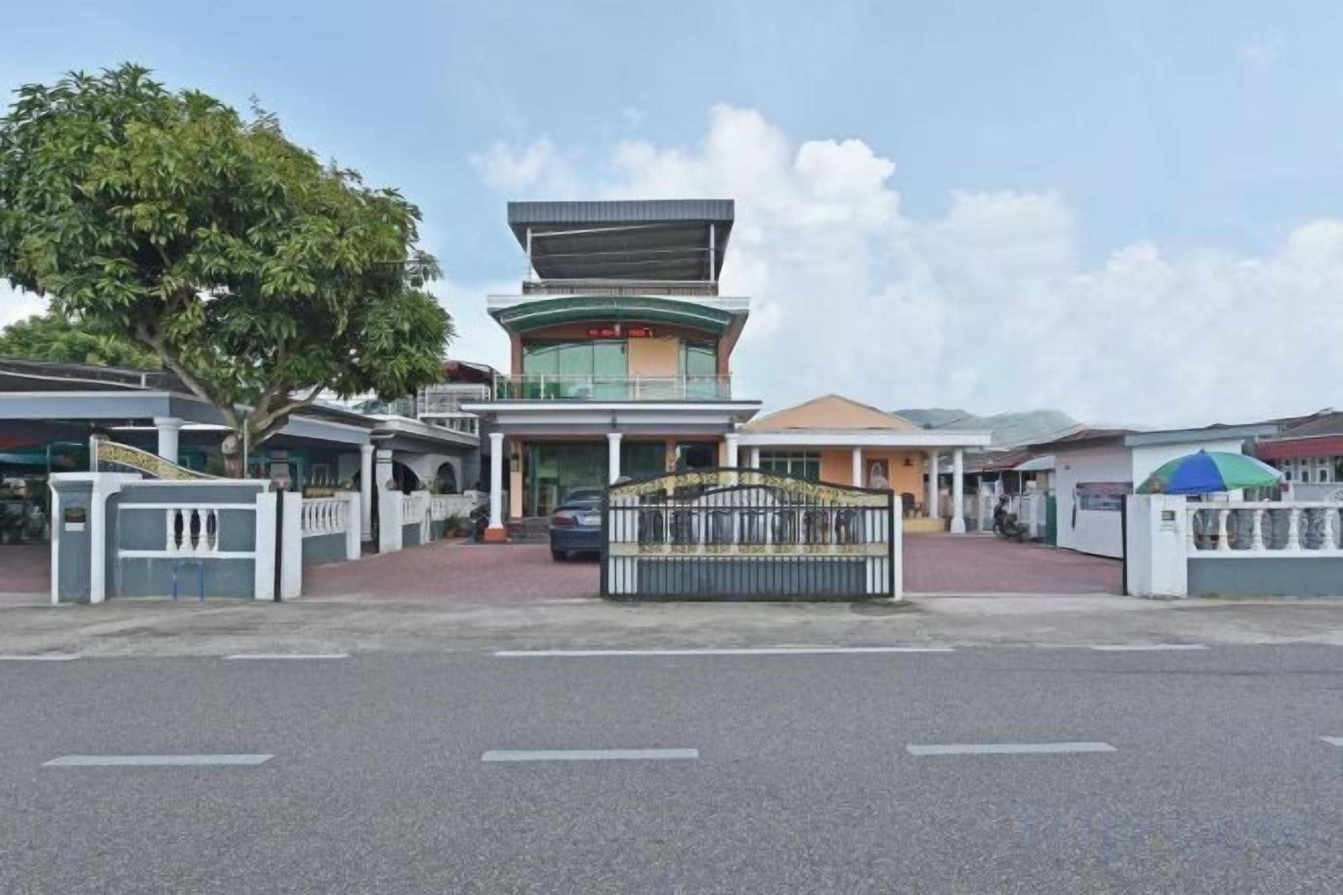 A building with a central tower, a gated entrance, and a covered walkway.