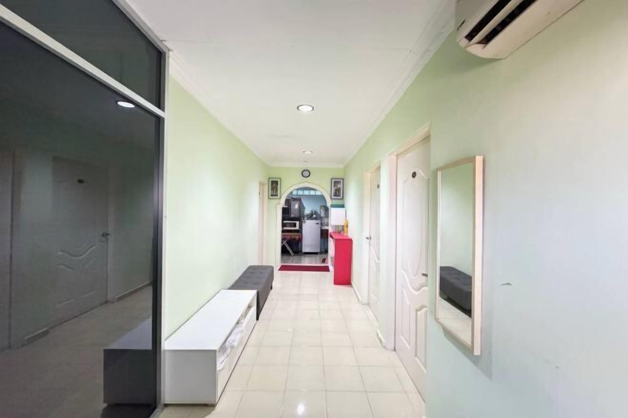 A hallway with a bench, a door, and a mirror on the wall.