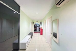 A hallway with a bench, a door, and a mirror on the wall. - Darul Salam Orkid Inn (Kerteh)