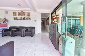 A hotel lobby with a reception desk, seating area, and a staircase leading to other floors. - Darul Salam Orkid Inn (Kerteh)