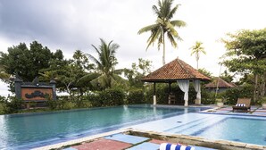 A pool area with lounge chairs and a gazebo. - lorin beach resort belitung (Tanjung Pandan)