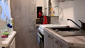 Une cuisine moderne équipée d’un four encastré, d’une machine à café et d’un évier.