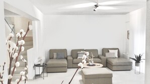 Una sala moderna con un sofá seccional, una mesa de centro y un ventilador de techo.