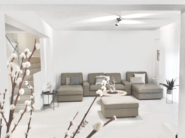 A modern living room with a sectional sofa, a coffee table, and a ceiling fan.