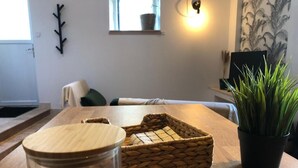 Une table en bois, un panier tressé, une plante en pot et un bocal en verre.