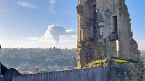 Une structure en pierre d’époque, avec une clôture en bois en premier plan.