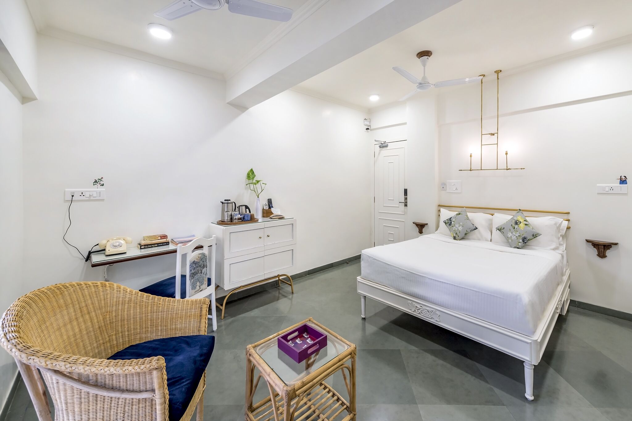 A bedroom with a bed, bedside table, chair, and a small table with a box.