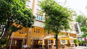 Een hotel met terras, een trap en een bordje met Bali Hotel erop.