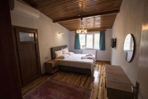 A bedroom with a wooden ceiling, a bed with white linens, a nightstand, a wooden dresser, and a window with curtains. - Ahsen Pansiyon (Selçuk)