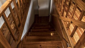 Eine Holztreppe mit einer weißen Tür oben.
