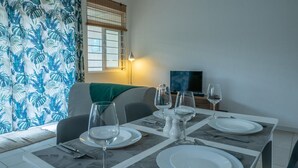 Un comedor con una mesa dispuesta para cuatro personas, con platos, vasos y cubiertos.