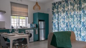 Un espacio habitable compacto con kitchenette, comedor y sofá.