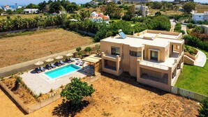 Et moderne hus med to etager, en swimmingpool, en indhegnet have og udsigt til havet.