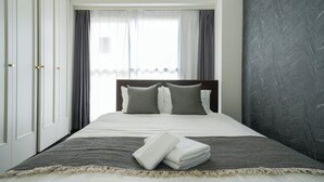 Ein Hotelzimmer mit Bett, Vorhängen und einer dunklen Wand.