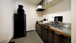 Eine kleine Küche mit Kühlschrank, Spüle und Schränken.