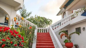 A staircase with red steps leading to a white building with balconies. - Kilifi Blue House Resort (Kilifi)