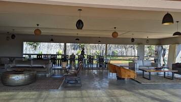 Un amplio espacio al aire libre con mobiliario moderno, una chimenea y vistas del paisaje circundante.