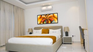 Una habitación de hotel moderna con una cama grande, una mesita de noche, un escritorio y una silla.