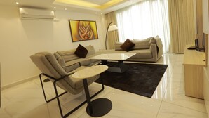 Una sala de estar moderna con sofá, mesa de centro y mueble para televisión.