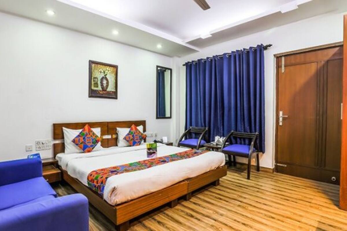 Una habitación de hotel con cama, sofá, escritorio y puerta.