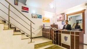 A hotel reception area with a staircase, reception desk, and various signs including one for 'fob hotels'. - FabHotel The Maple Stays - Nr. Leisure Valley Park, Iffco Chowk (Gurugram)