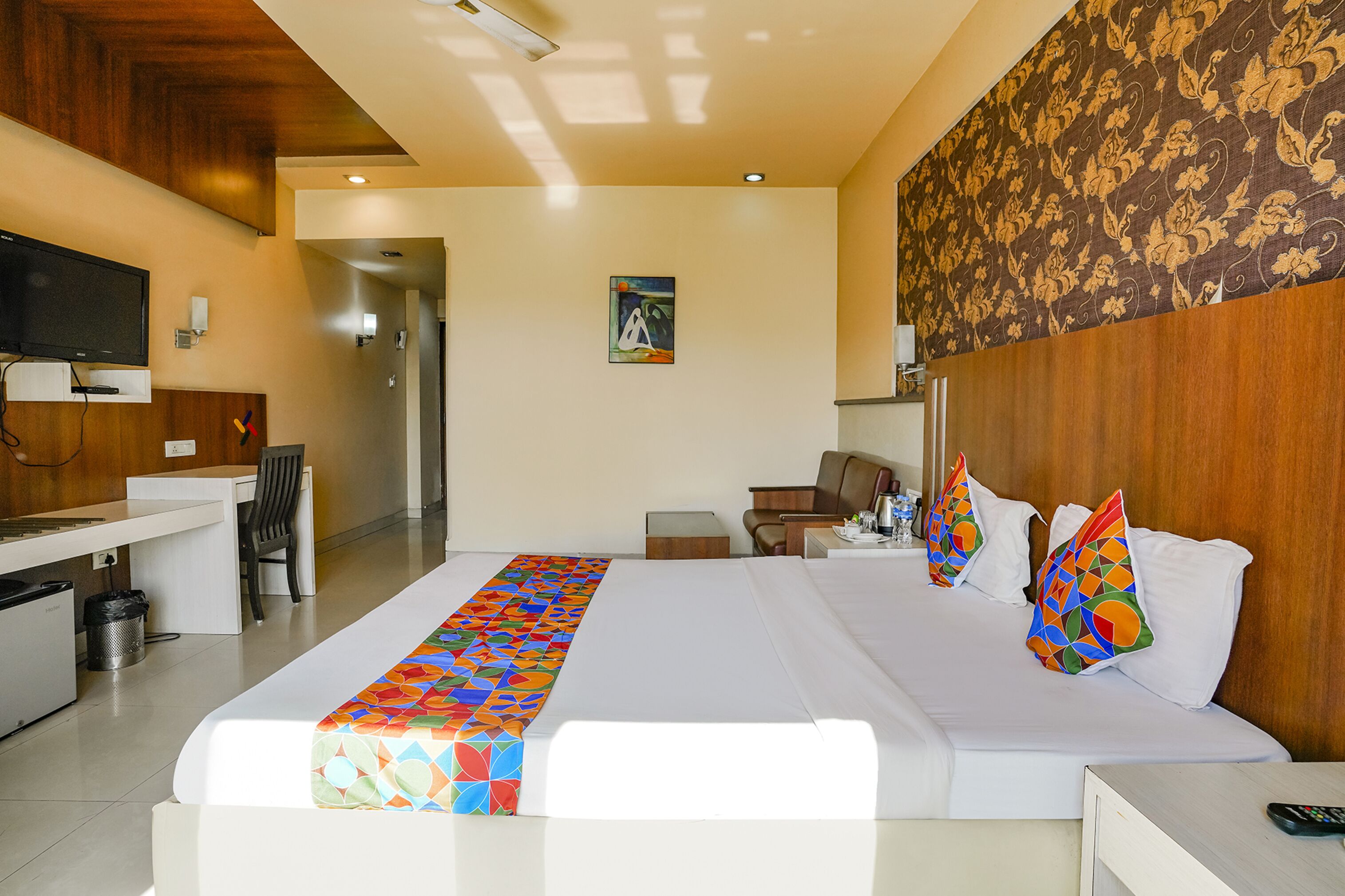 Une chambre d’hôtel comprenant un lit, un bureau, une chaise, une télévision et une salle de bain.