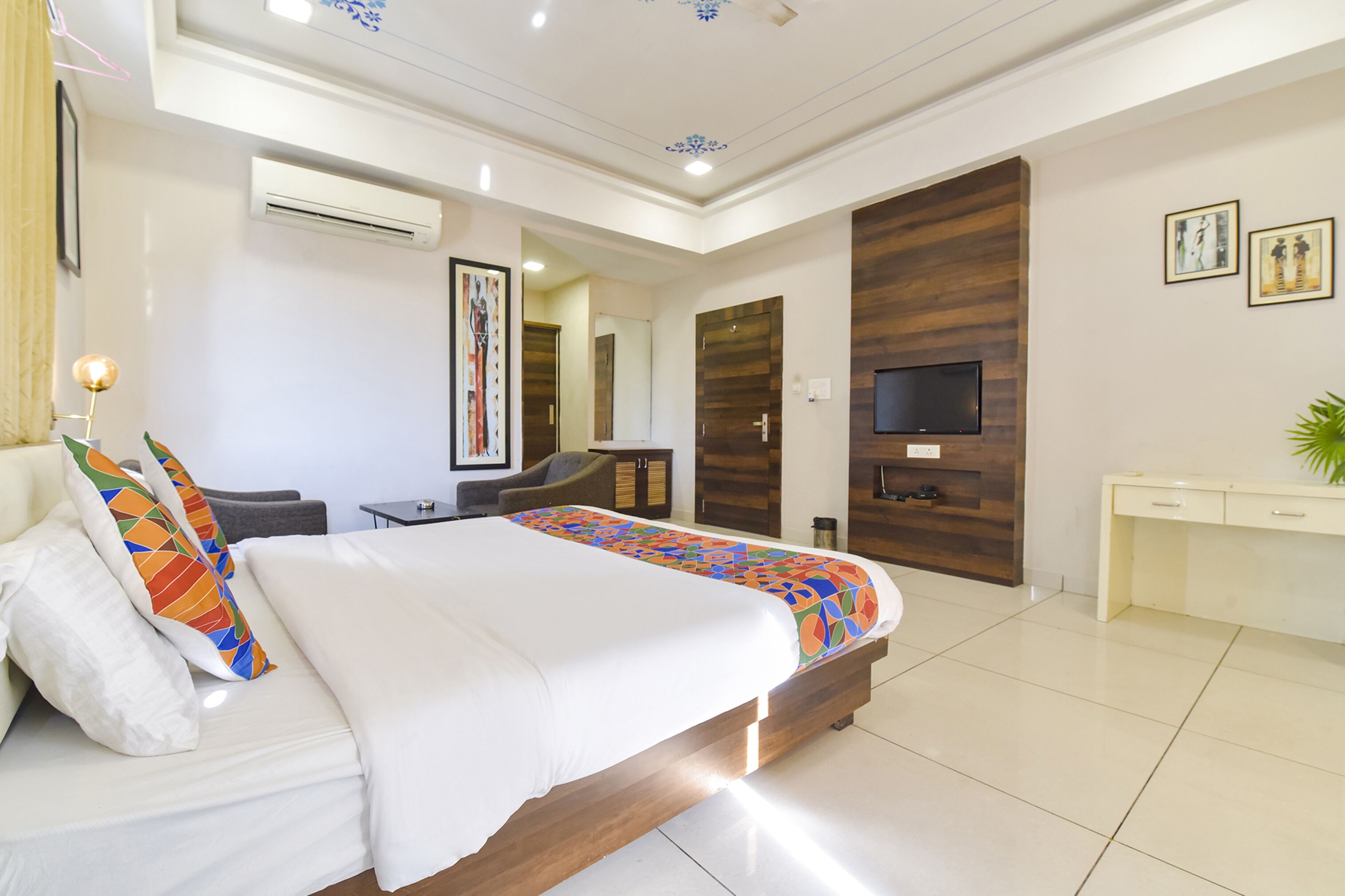 Une chambre d’hôtel moderne équipée d’un grand lit, d’une télévision, d’un bureau et d’une armoire.