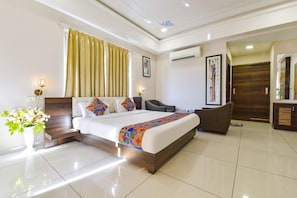 A modern hotel room with a large bed, a desk, a chair, and a wardrobe. - Fabhotel Prime Kingfisher (Udaipur)