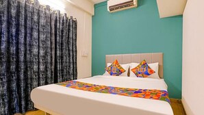 Un dormitorio con cama, paredes color verde azulado y una ventana con cortinas.