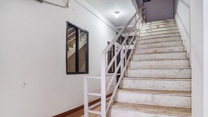 Eine Treppe mit weißen Geländern und Fliesenboden.