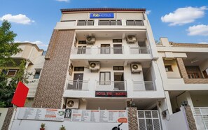 Een meerhoog gebouw met een bord waarop 'fabHOTELS' en 'HOTEL THE VINAYAN' staat.