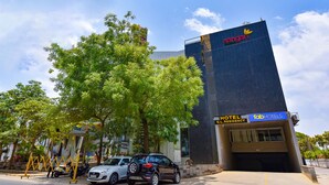 Um edifício moderno com a placa 'aangan', a placa 'fab hotels' e a placa 'hotel residency'.