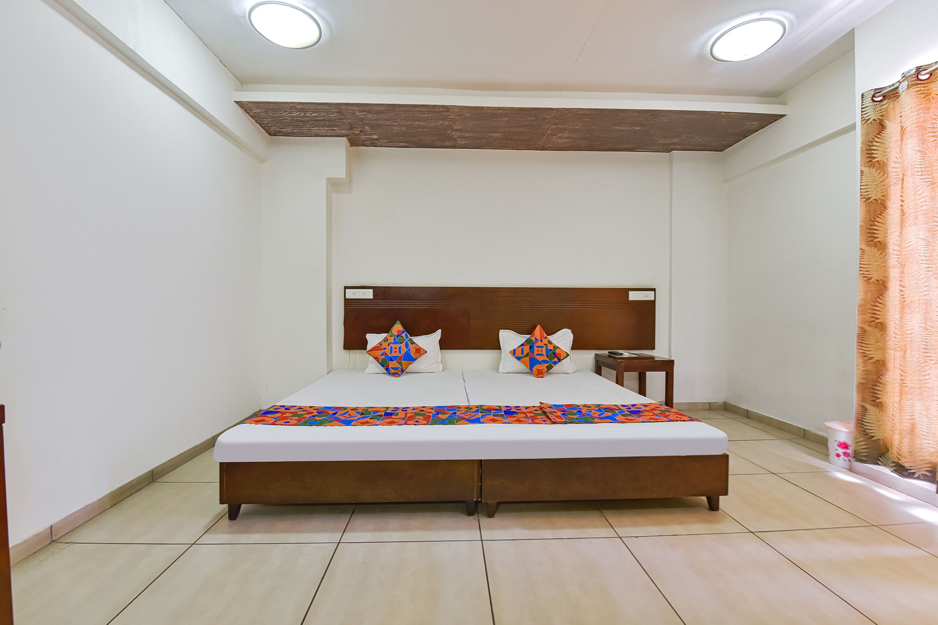 Una camera da letto con un letto grande, due comodini, una testiera in legno e una coperta a motivi.