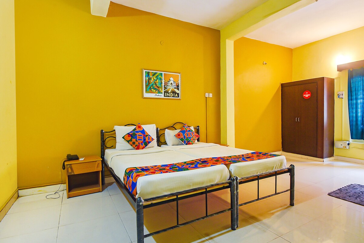 A room with a bed, a nightstand, a wardrobe, and a wall with a framed picture.