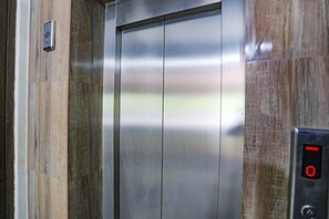 An elevator with a metallic interior and a digital display showing "0". - Fabhotel Royal Stay Inn (Prayagraj)
