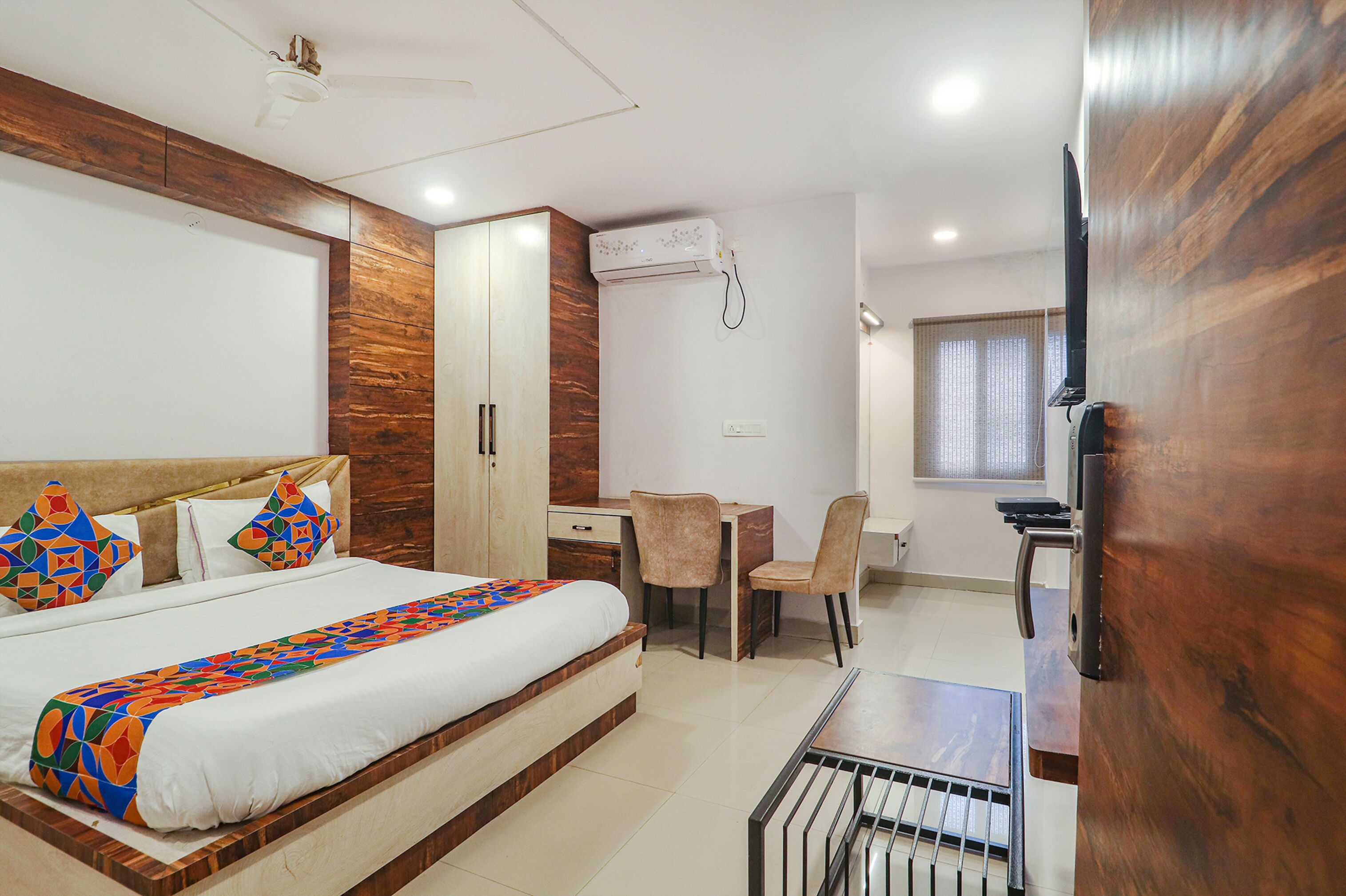 Une chambre d’hôtel équipée d’un lit, d’un bureau, d’une chaise, d’un climatiseur et d’un téléviseur.