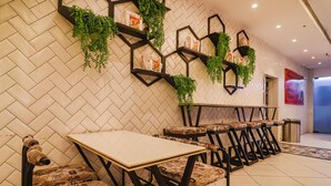 A restaurant interior with hexagonal shelves, green plants, and a tiled floor. - Fabhotel Double Tree (Hyderabad)