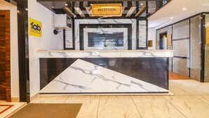 A reception desk with a marble design, a reception sign, and a 'fab hotels' sign. - Fabhotel Double Tree (Hyderabad)