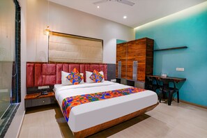 Un dormitorio moderno con una cama grande, un armario de madera, un escritorio con dos sillas y un ventilador de techo.
