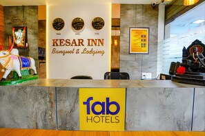 Un mostrador de recepción de hotel con un letrero de 'fab hotels' y relojes que marcan la hora en Dubái, India y Estados Unidos.