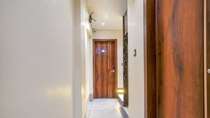 A hallway with a wooden door labeled "201" and a security camera above it. - Fabhotel Benchmark (Indore)