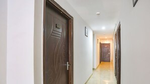Un pasillo con una puerta de madera marcada con el número 302 y piso de baldosas.