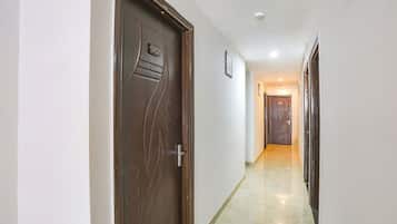 A hallway with a wooden door marked "302" and a tiled floor.